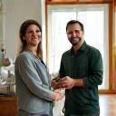 Homeowner smiling and shaking hands with a contractor in a beautifully completed renovated living room
